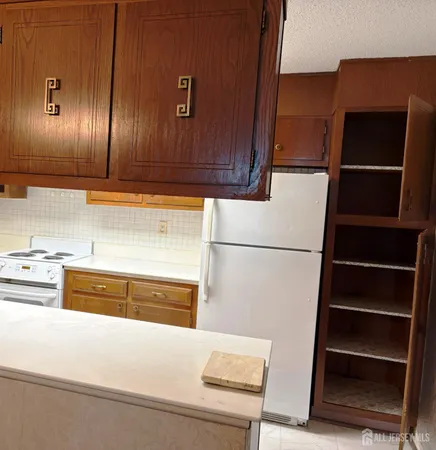 a view of a refrigerator in kitchen and wooden floor