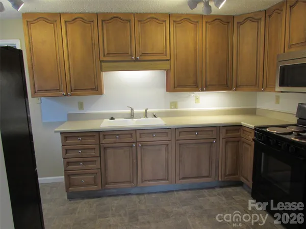 a kitchen with stainless steel appliances granite countertop a sink a stove and a microwave