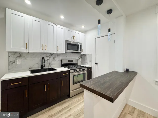 a kitchen with kitchen island a sink stove and microwave