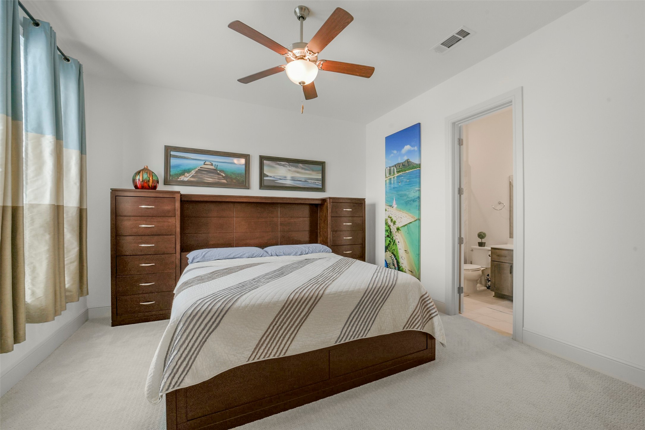 2018 Grove Terrace Lane Manvel, TX 77578 - Photo 18 of 50 Private guest bedroom features a comfortable setup with a cozy bed, ample drawer storage, and a calming sitting area. It includes an en-suite bathroom and is adorned with a ceiling fan for comfort.
