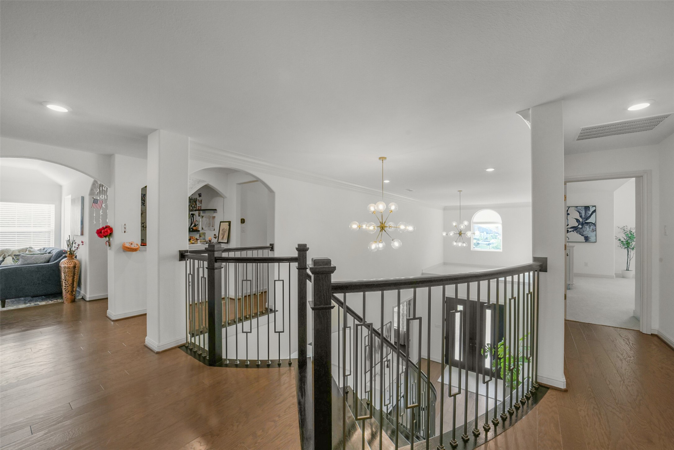 2018 Grove Terrace Lane Manvel, TX 77578 - Photo 29 of 50 Bright, upstairs open hallway with modern lighting and elegant upgraded railing overlooking a staircase. The hardwood floors complement the neutral walls, and there are spacious, well-lit rooms visible on either side.