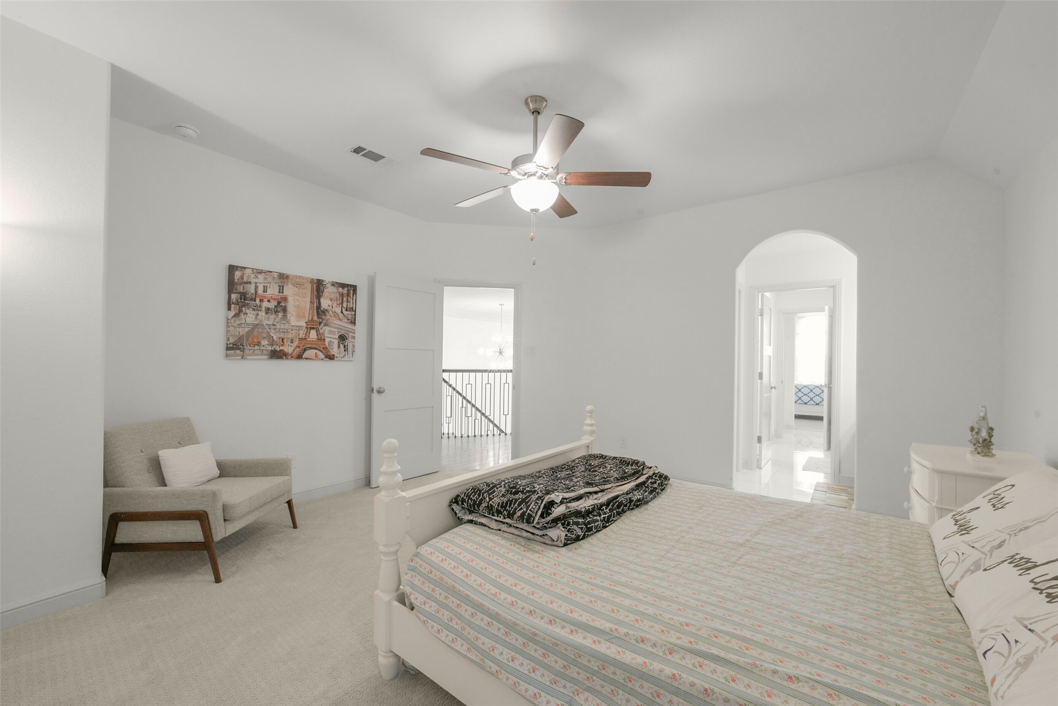 2018 Grove Terrace Lane Manvel, TX 77578 - Photo 35 of 50 Another spacious, bright bedroom features neutral decor, a ceiling fan, and a comfortable bed. It includes a cozy sitting area, and an en-suite bathroom is accessible through an arched doorway, custom built in closet. The room offers a serene and inviting atmosphere.