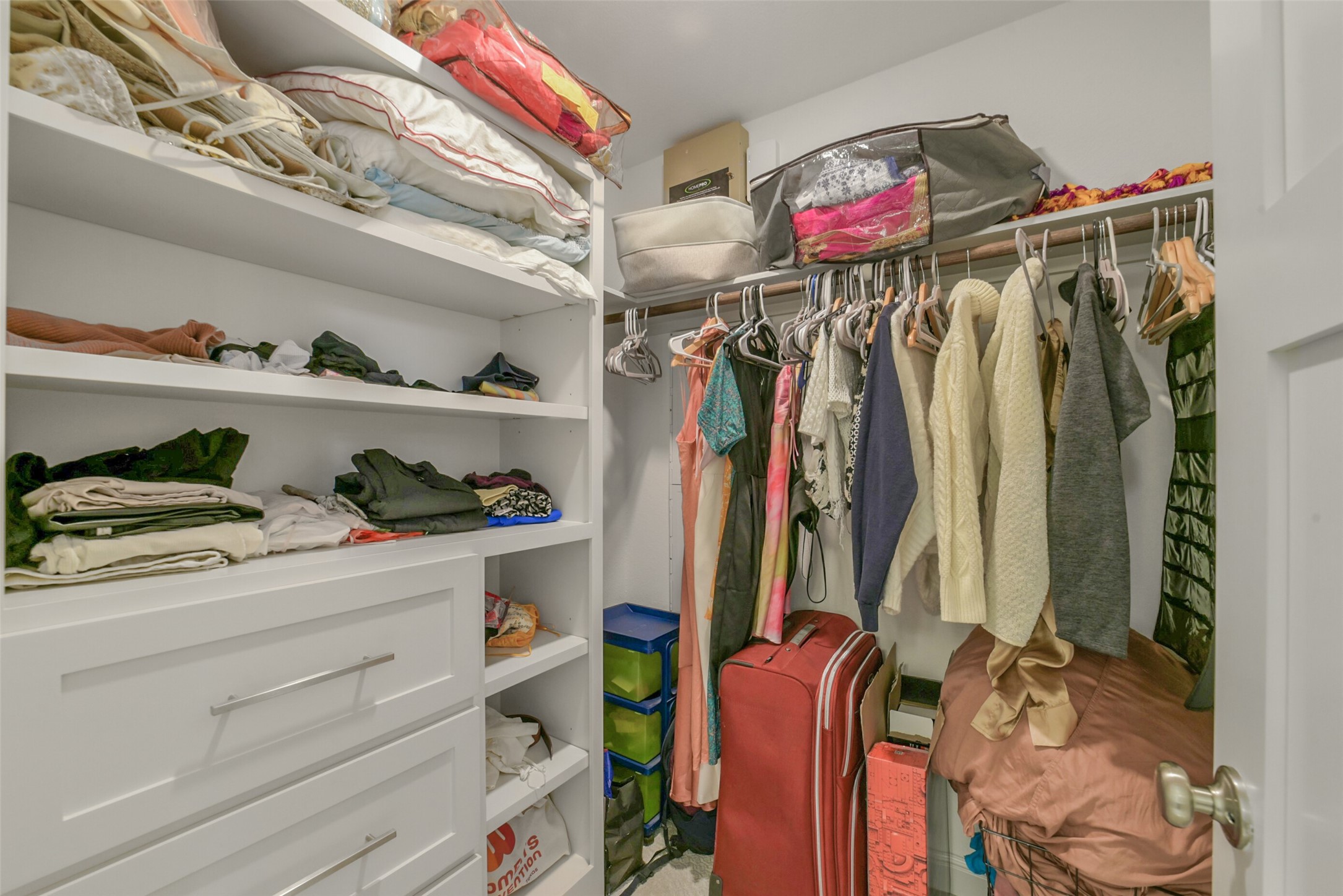 2018 Grove Terrace Lane Manvel, TX 77578 - Photo 37 of 50 This photo showcases a spacious walk-in custom closet with ample shelving and hanging space. It features neatly organized clothes, a variety of storage containers, and drawers for additional storage, making it ideal for keeping belongings tidy and accessible.