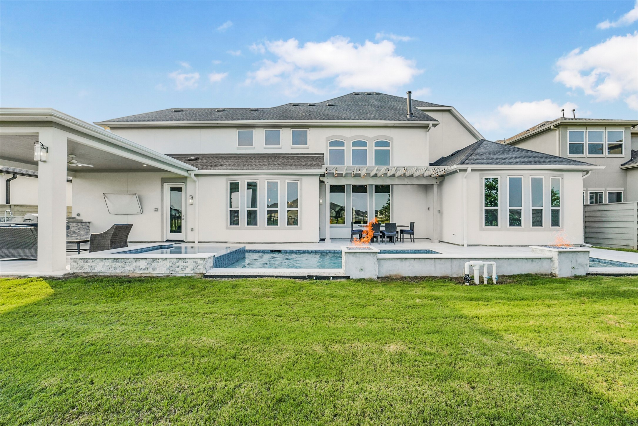 2018 Grove Terrace Lane Manvel, TX 77578 - Photo 39 of 50 Modern two-story home with a spacious no back neighbors' backyard, featuring a covered patio area, a swimming pool, and ample windows for natural light. Ideal for outdoor entertaining.
