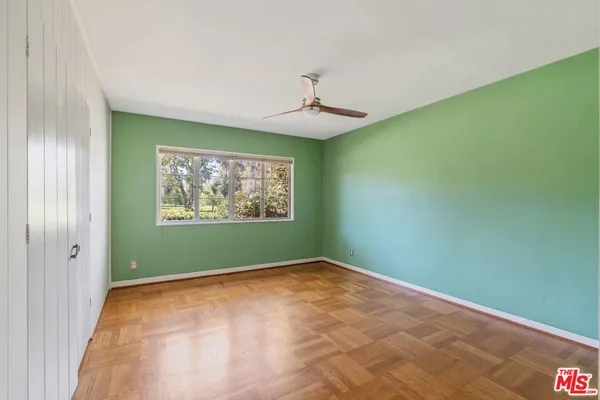 an empty room with window and a ceiling fan