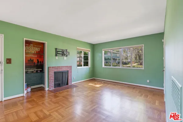 a view of empty room with window and fireplace