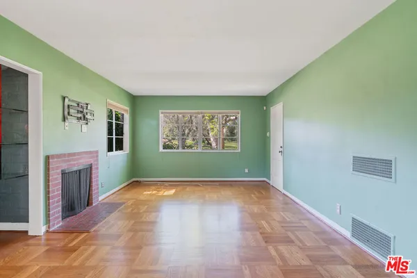 a view of an empty room with a window and a fireplace