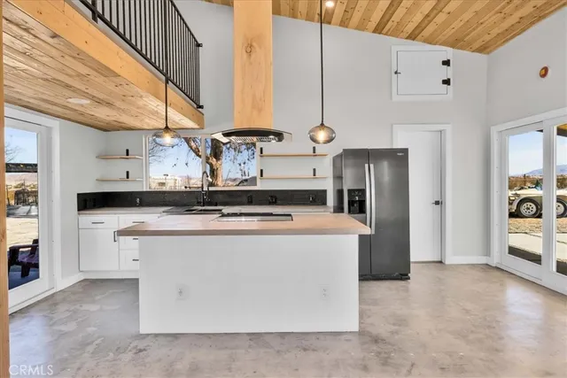 a kitchen with stainless steel appliances granite countertop a sink a stove and a wooden floors