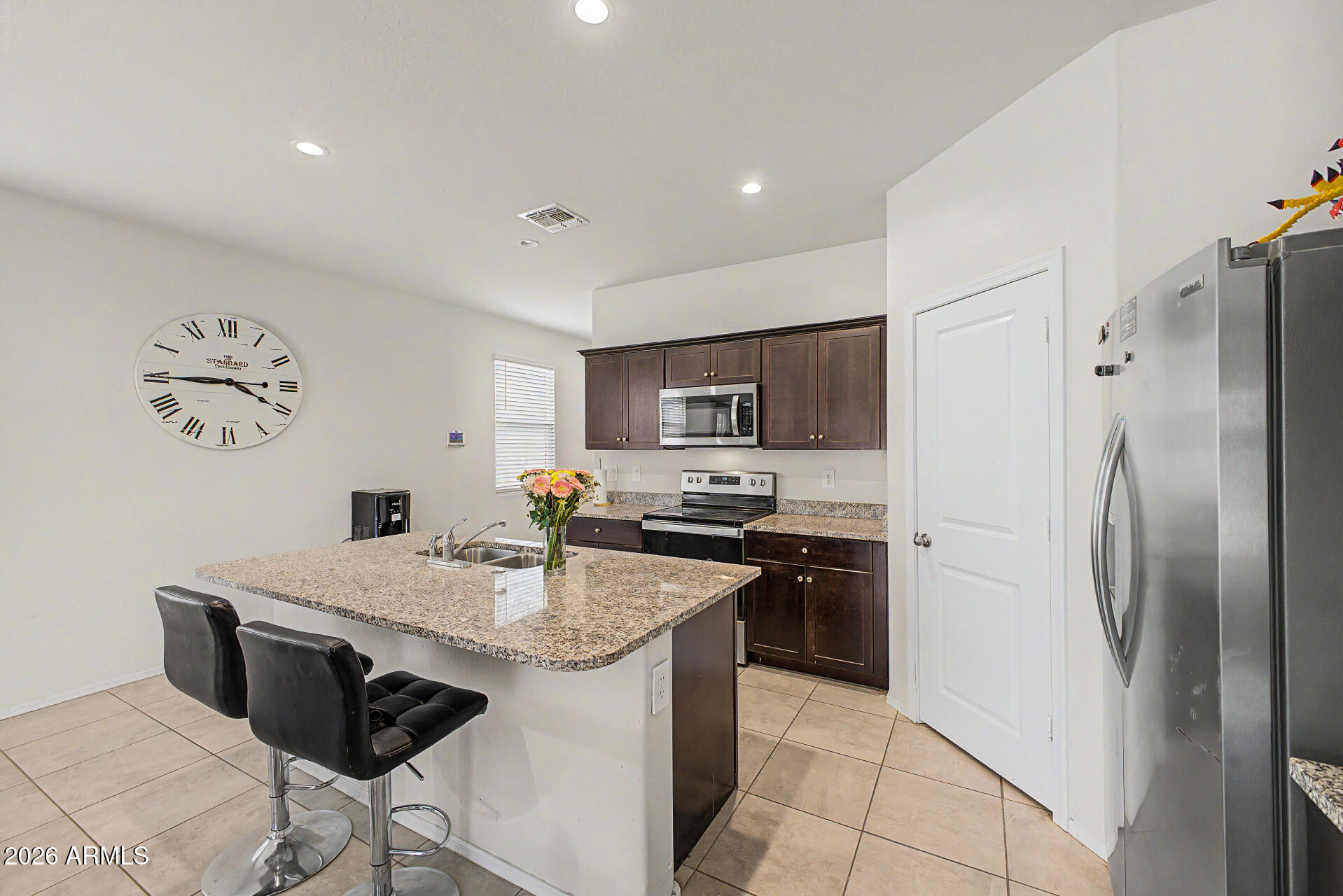 9345 Tangerine Road Florence, AZ 85132 - Photo 13 of 30 a kitchen with stainless steel appliances granite countertop a refrigerator a sink a stove a dining table and chairs