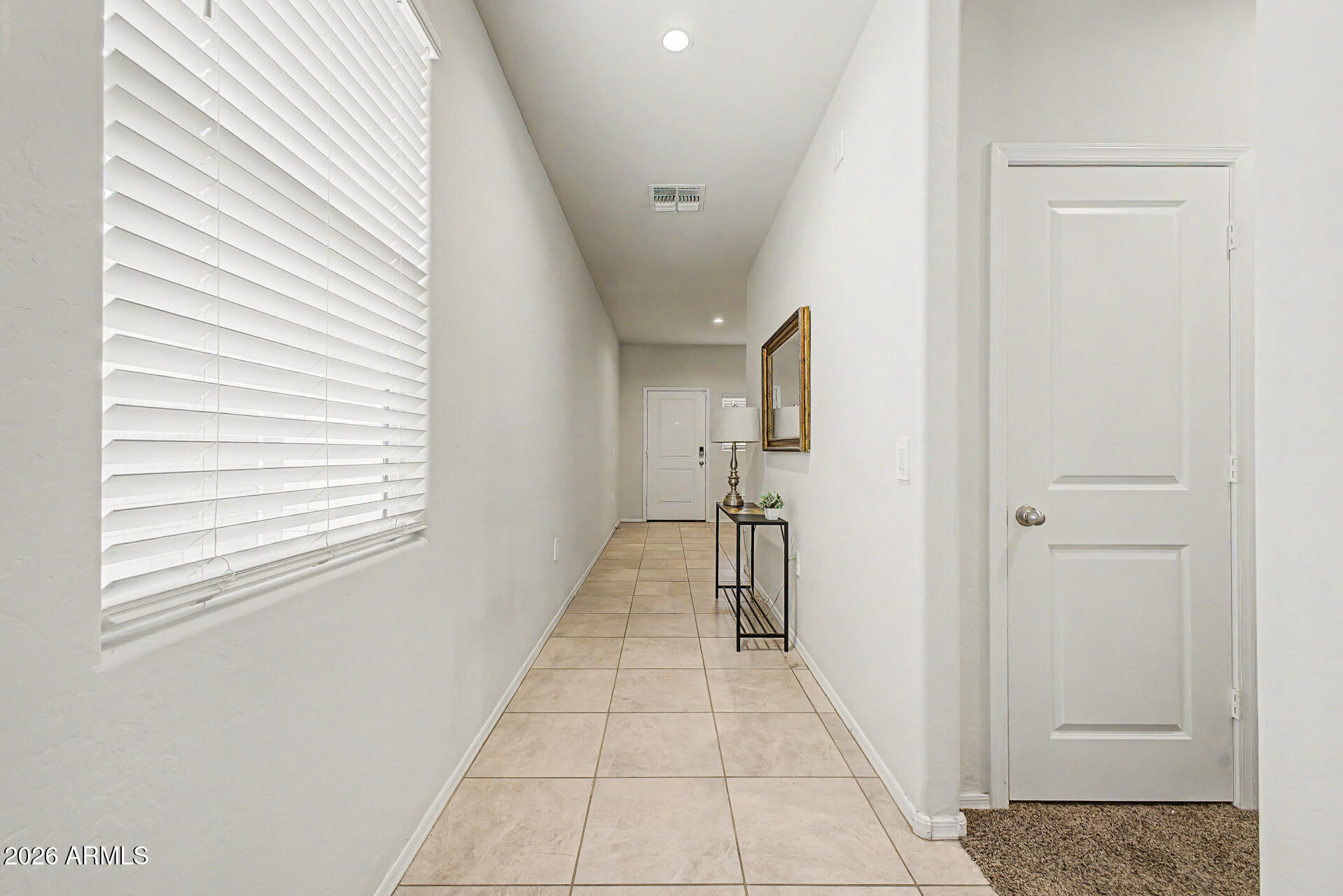 9345 Tangerine Road Florence, AZ 85132 - Photo 6 of 30 a hallway with a black white checkered floor and a white cabinet