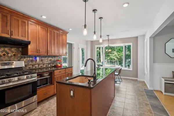 a kitchen with kitchen island a stove a sink and wooden cabinets