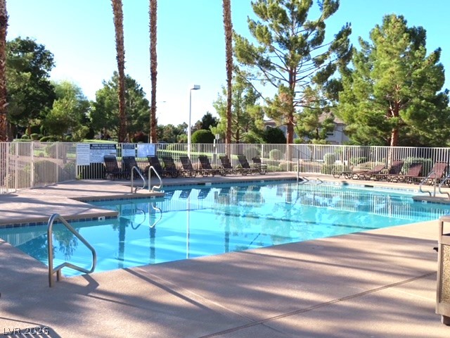 1623 Cave Spring Drive Henderson, NV 89014 - Photo 12 of 16 A refreshing pool awaits, surrounded by ample lounge seating within a gated community.