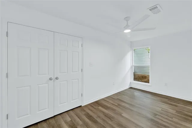 a view of an empty room with wooden floor