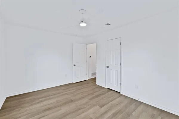 a view of a room with wooden floor and white walls