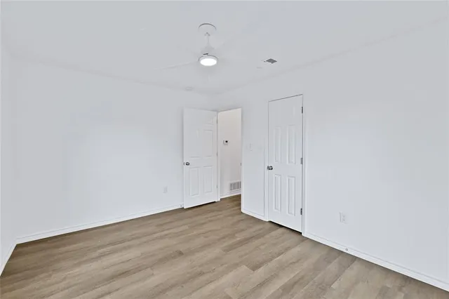 a view of a room with wooden floor and white walls