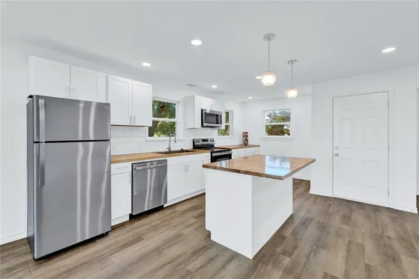 a view of a kitchen with a sink and a refrigerator