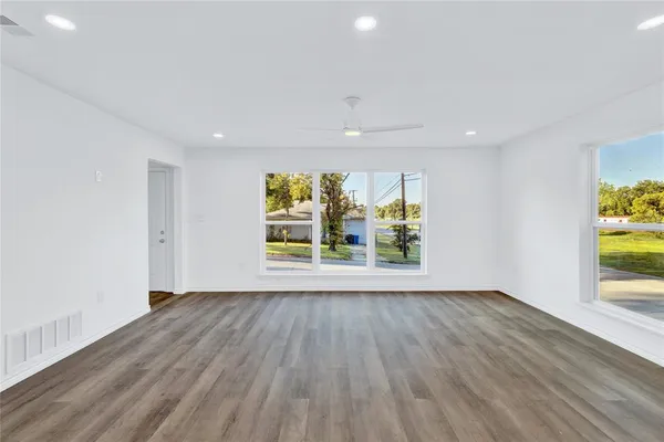 a view of an empty room with wooden floor