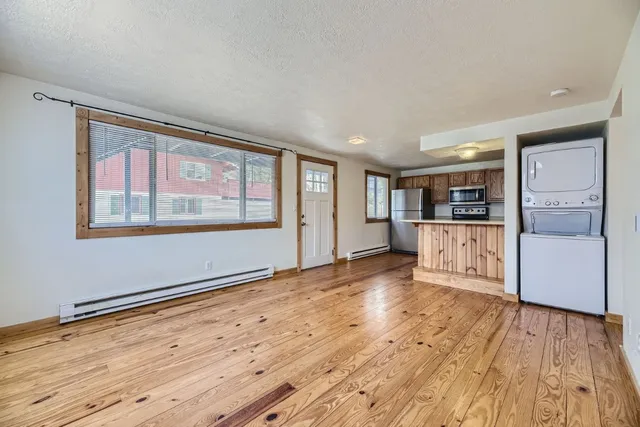 a view of a kitchen with wooden floor and windows