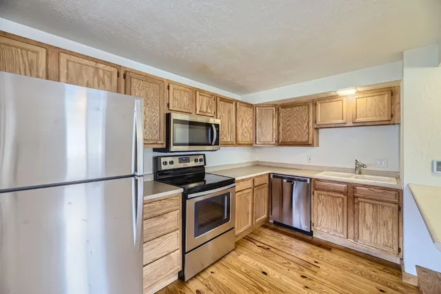 a kitchen with stainless steel appliances a refrigerator stove microwave and sink