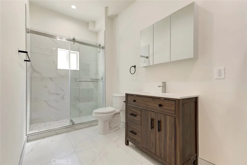 7044 Greeley Street Tujunga, CA 91042 - Photo 14 of 27 a bathroom with a shower toilet sink and cabinets