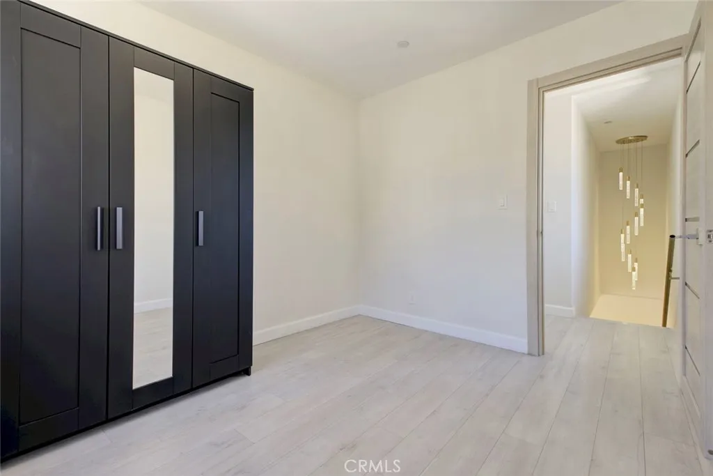 7044 Greeley Street Tujunga, CA 91042 - Photo 18 of 27 an empty room with wooden floor and a bathroom