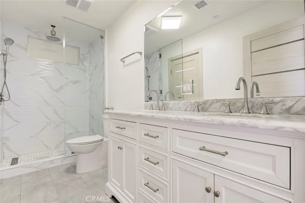 7044 Greeley Street Tujunga, CA 91042 - Photo 20 of 27 a bathroom with a granite countertop toilet sink and mirror