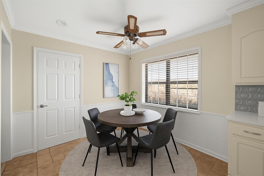 10 Estates Road Lucas, TX 75002 - Photo 11 of 39 Dining space with wainscoting, crown molding, ceiling fan, and light tile patterned flooring