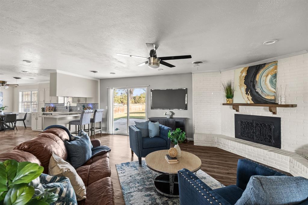 10 Estates Road Lucas, TX 75002 - Photo 2 of 39 Living area with a ceiling fan, a textured ceiling, wood finished floors, plenty of natural light, and ornamental molding