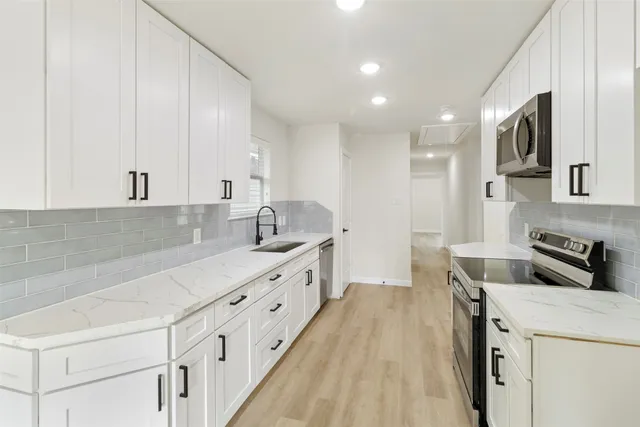 a kitchen that has a lot of cabinets in it and appliances