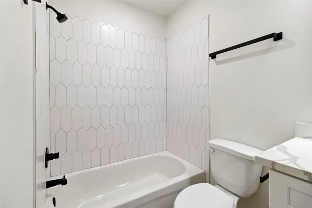a white bath tub sitting next to a white toilet and sink