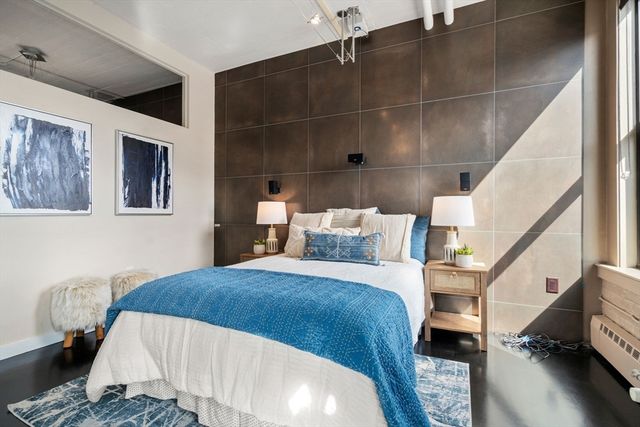 a bedroom with a bed and wooden floor