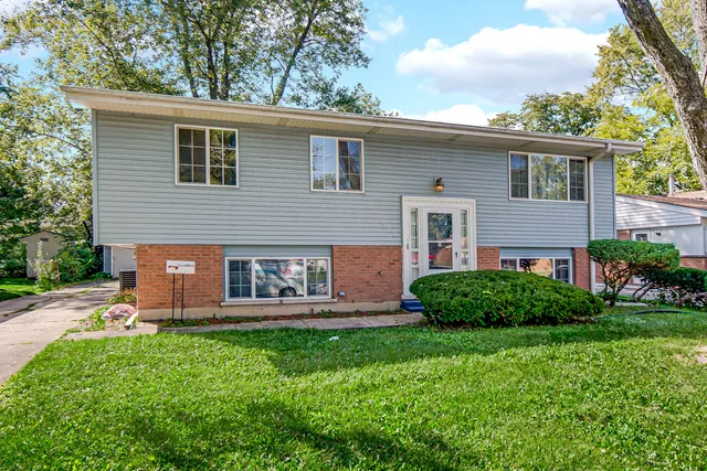 a front view of a house with garden and yard