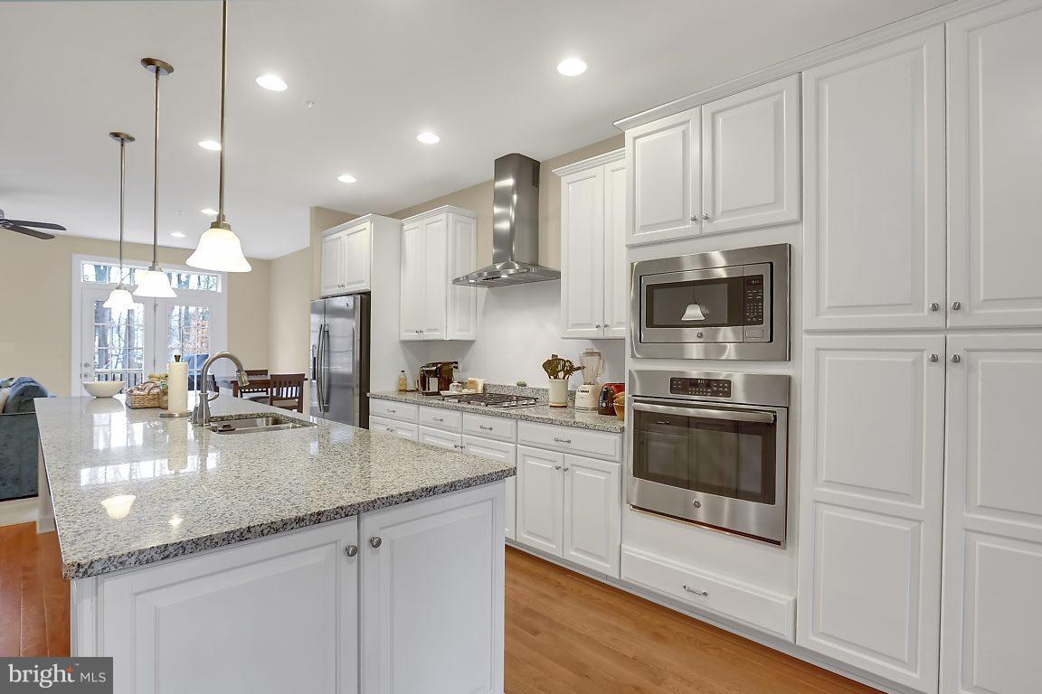 7872 Patterson Way Hanover, MD 21076 - Photo 14 of 26 a kitchen with stainless steel appliances granite countertop a sink a stove and a refrigerator