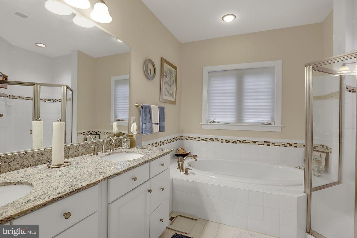 7872 Patterson Way Hanover, MD 21076 - Photo 19 of 26 a bathroom with a granite countertop tub sink and mirror