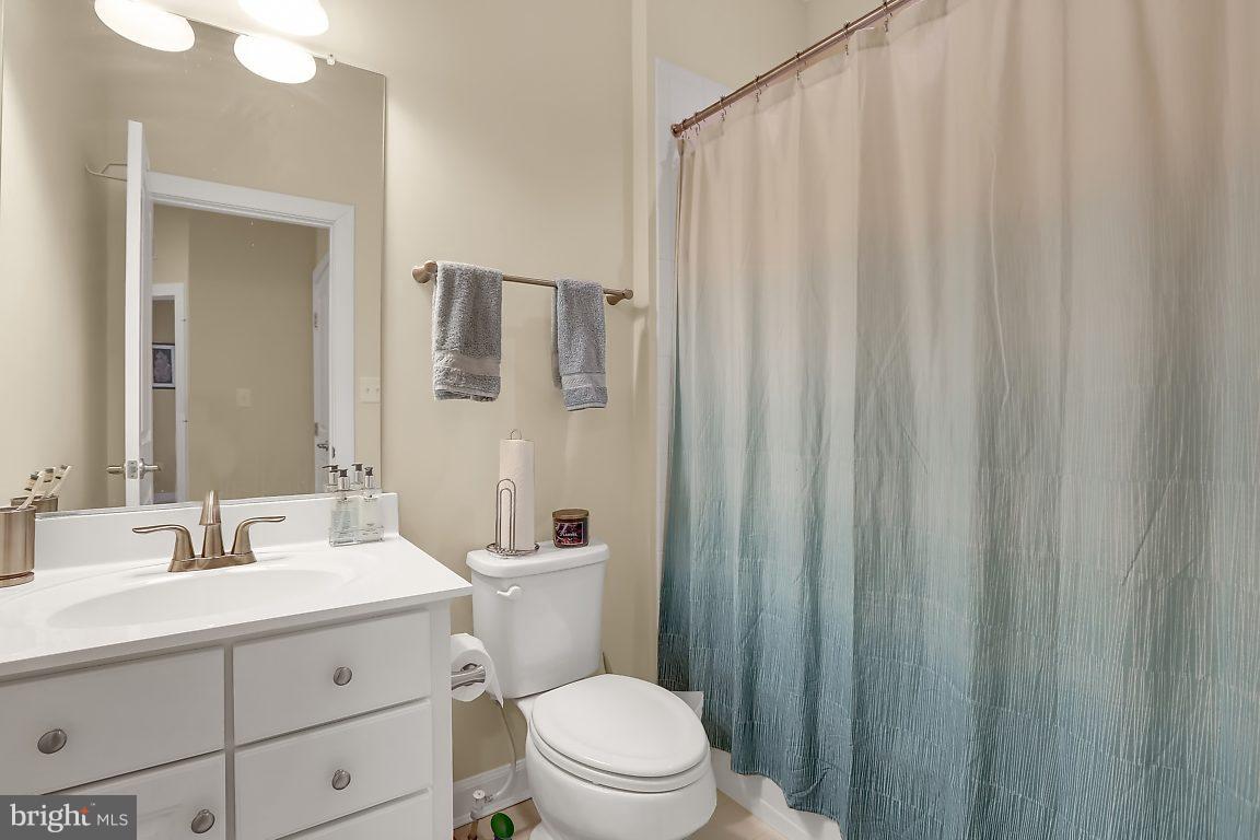 7872 Patterson Way Hanover, MD 21076 - Photo 22 of 26 a bathroom with a sink a toilet a mirror and shower curtain