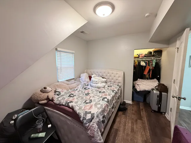 a bedroom with a bed and wooden floor