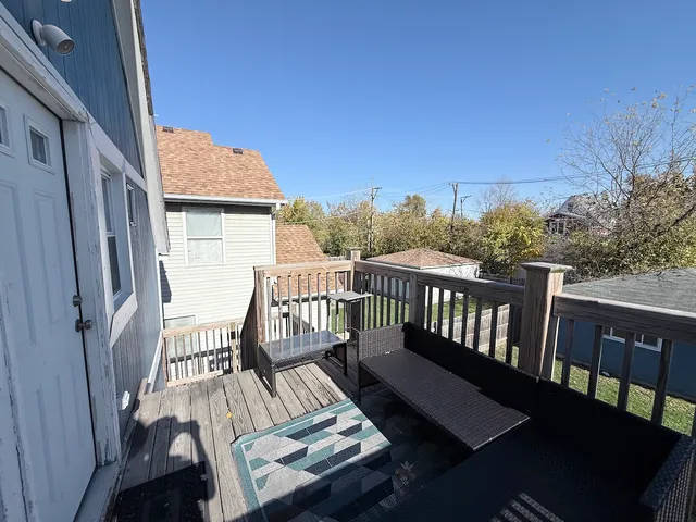 a view of a balcony with wooden floor and outdoor seating