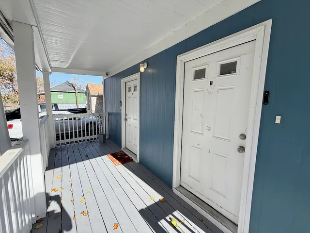 a view of a hallway with wooden floor and windows