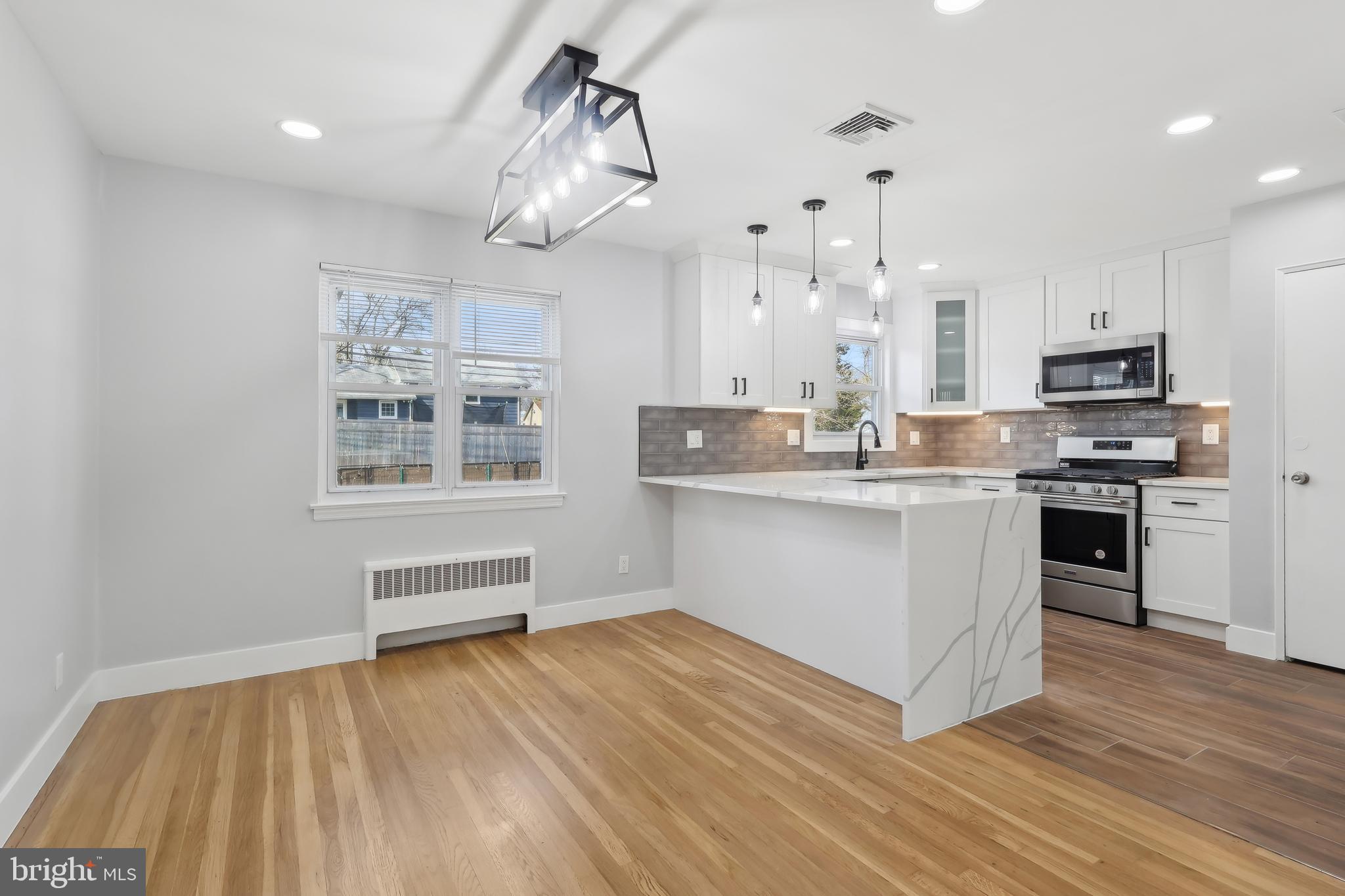 904 Big Oak Road Yardley, PA 19067 - Photo 16 of 56 a kitchen with stainless steel appliances a white stove top oven cabinets and a wooden floor