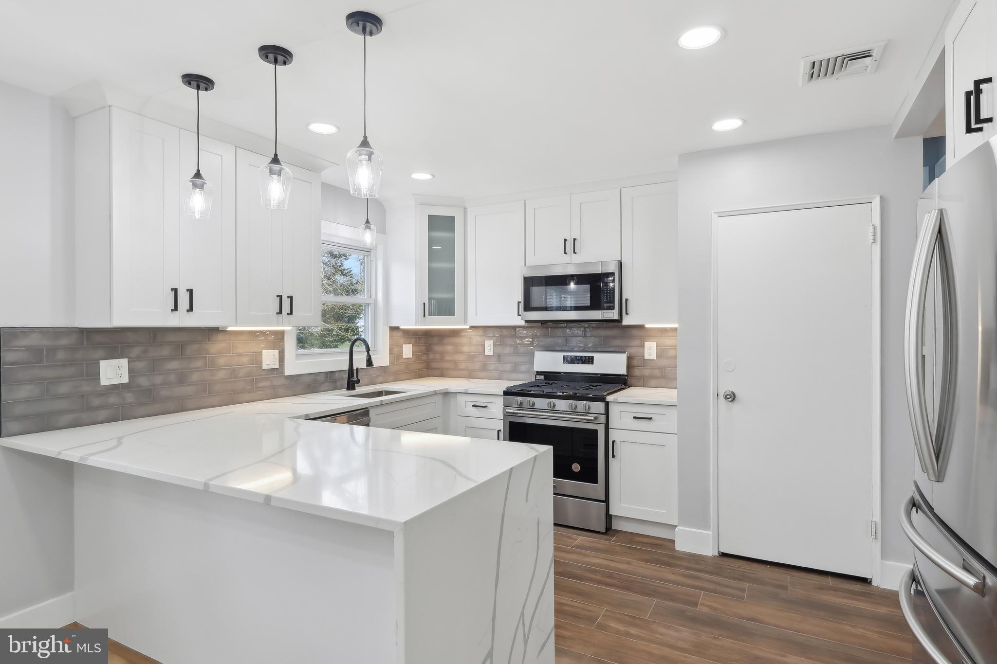 904 Big Oak Road Yardley, PA 19067 - Photo 21 of 56 a kitchen with stainless steel appliances a sink a stove a refrigerator and cabinets
