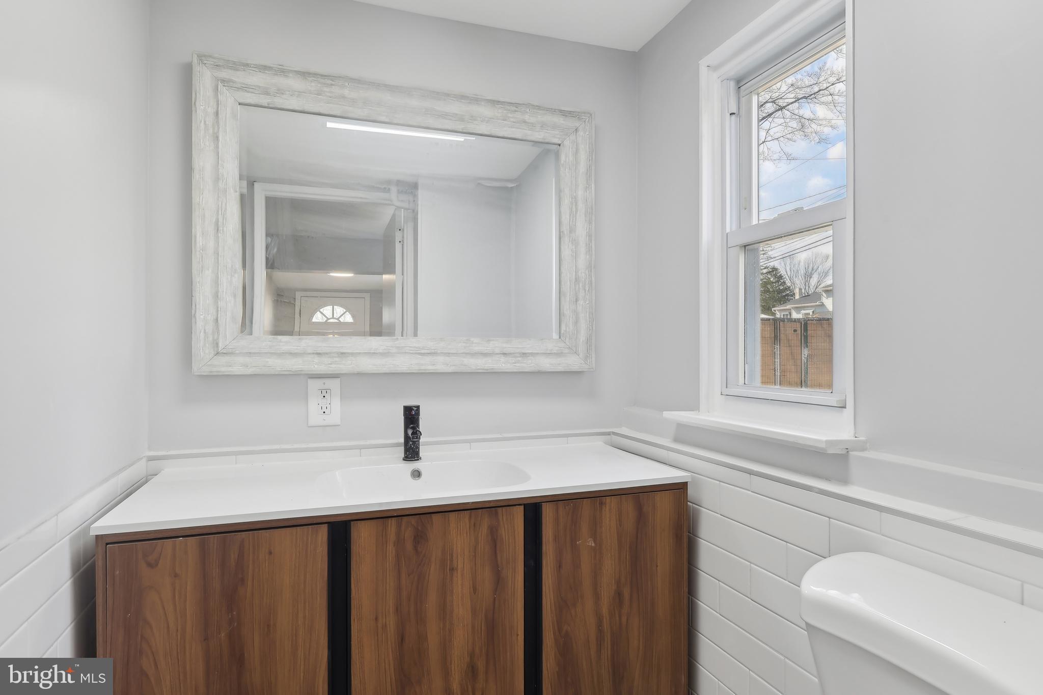 904 Big Oak Road Yardley, PA 19067 - Photo 25 of 56 a bathroom with a sink a mirror and a window