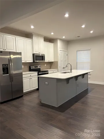 a kitchen with stainless steel appliances a sink a stove a microwave and cabinets