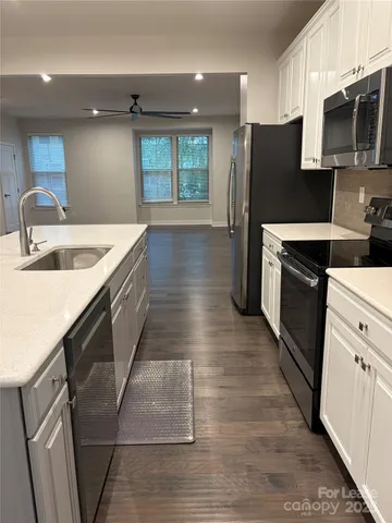 a kitchen with stainless steel appliances granite countertop a sink a stove and a refrigerator