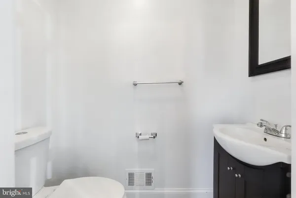 a bathroom with a toilet a sink a mirror and bathtub