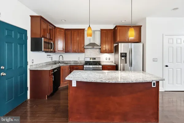 a kitchen with stainless steel appliances granite countertop wooden floors sink and cabinets