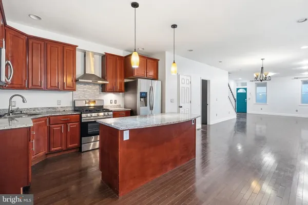 a kitchen with stainless steel appliances a refrigerator and wooden floor