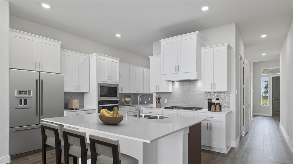 1019 Pitchfork Road Royse City, TX 75189 - Photo 8 of 25 a kitchen with a sink a stove a refrigerator and white cabinets with wooden floor