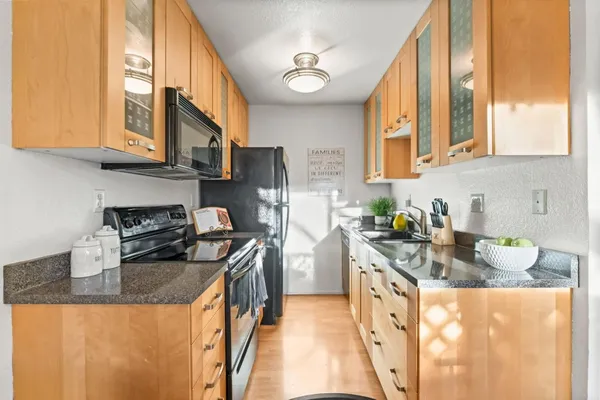 a kitchen with granite countertop a sink a stove and a granite counter top