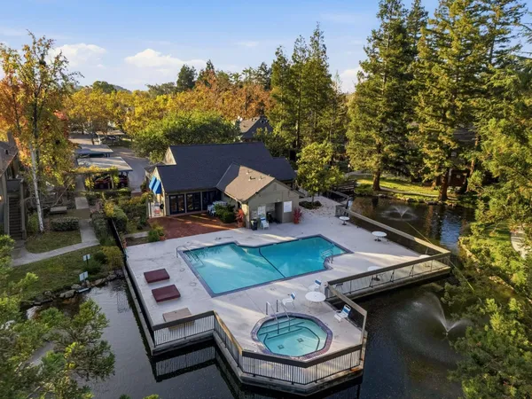 an aerial view of a house with swimming pool and lake view