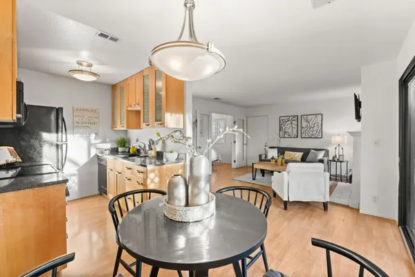 a dining room with furniture a chandelier and wooden floor